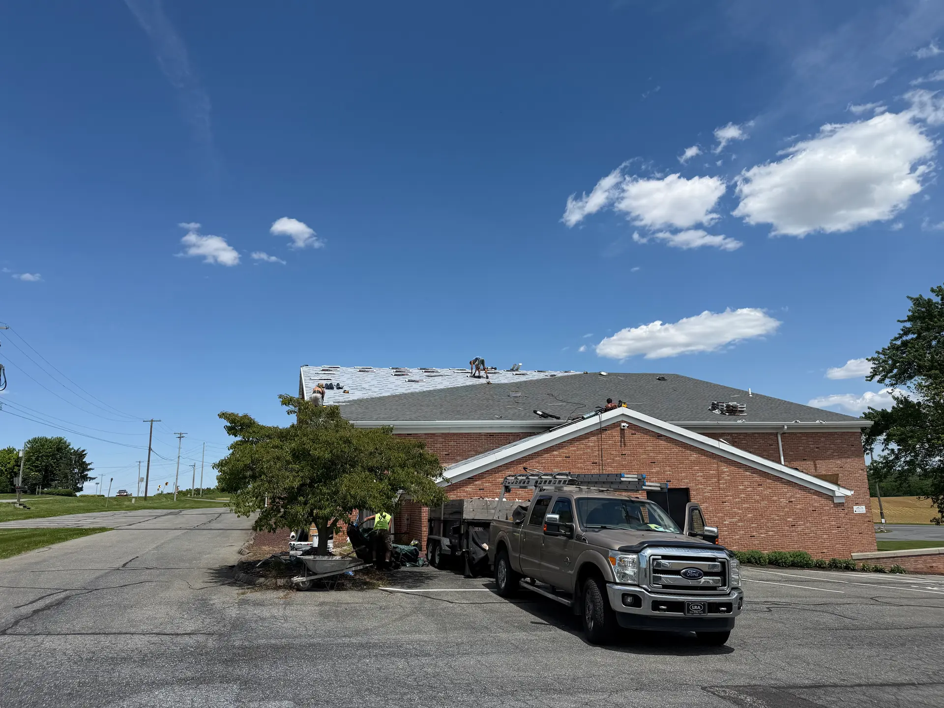 Commercial building re-roof in progress with Quietstorm Exteriors truck on site