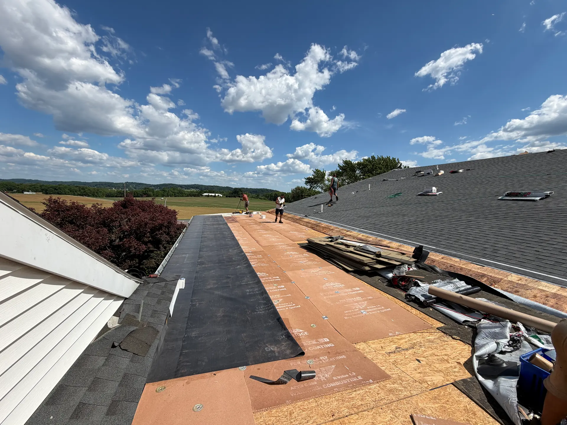 Roof edge with crisp white fascia overlooking Lancaster County farmland, by Quietstorm Exteriors