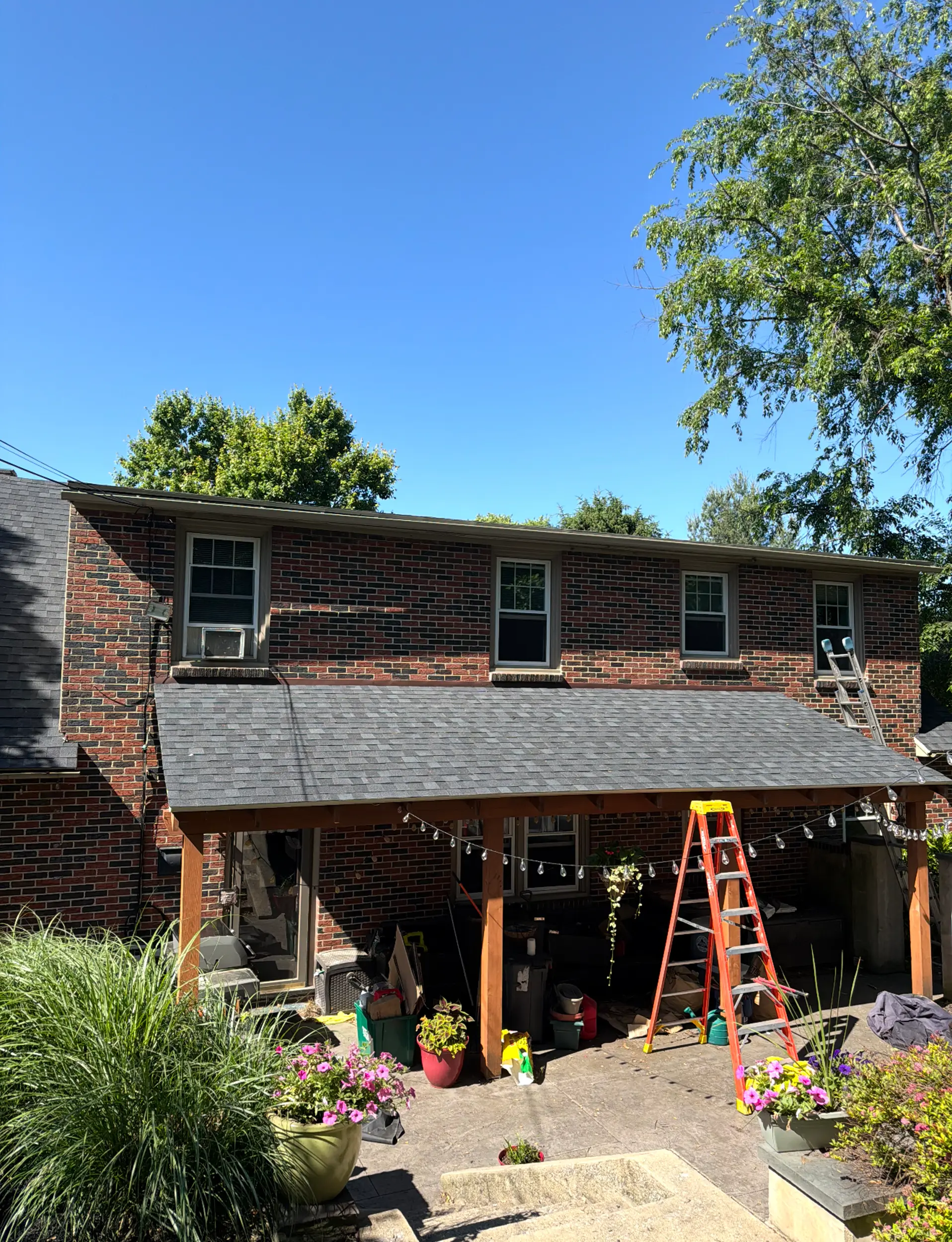 Brick home with new roofing and clean gutter line installed by Quietstorm Exteriors