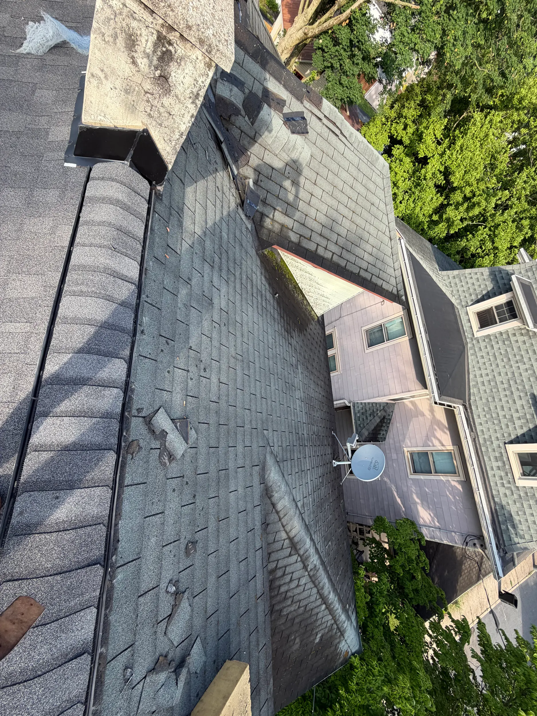 Aerial view of a roof and chimney being inspected and repaired by Quietstorm Exteriors